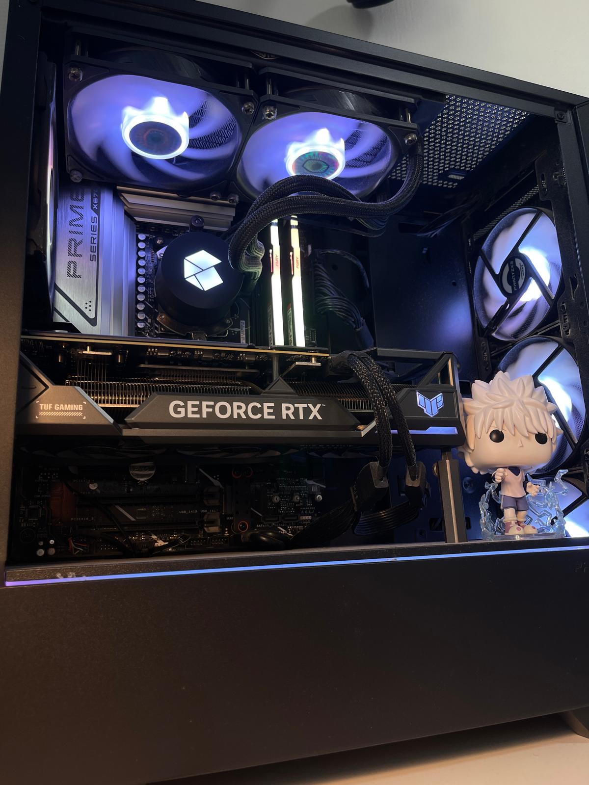 Personal PC build with white and purple lighting, visible components, and a Funko Pop figure inside the case.